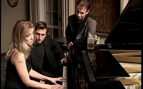 Beauteous whore playing piano together with two cocks